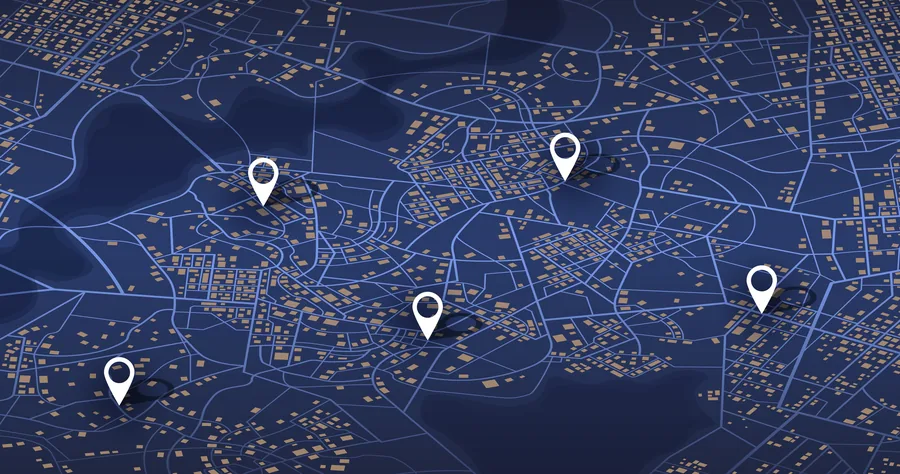 Dark map of a city overlaid with white location pins